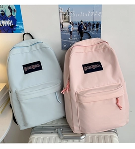 Vista de detalle de mochilas de lona rosa y azul con bolsillos frontales en maleta