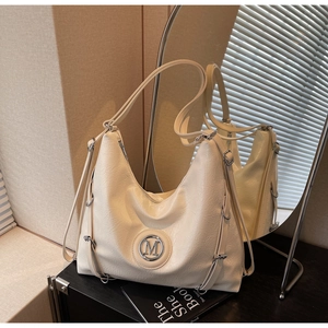 Détail du sac hobo crème avec texture en cuir froissé et logo M métallique