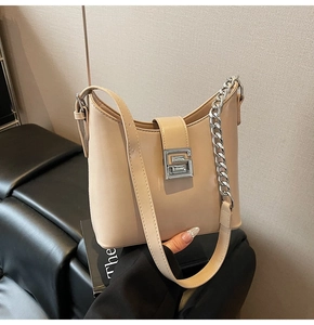 Detailed close-up of the silver G-shaped buckle and fine leather texture of the beige bag