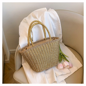 Detail of metallic woven tote bag with cylindrical handles and bohemian texture style