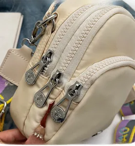 Détails des fermetures éclair en métal argenté du sac à bandoulière en nylon crème