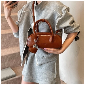 Détail du sac bowling marron caramel avec texte embossé et pendentif en forme de cœur
