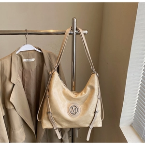 Vue détaillée du sac en cuir PU beige avec ornement M en métal et bandoulière