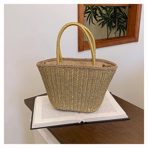 Detail of golden woven tote bag with smooth handles and soft fabric lining inside