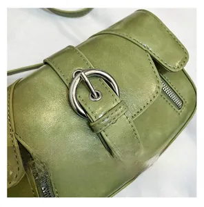 Detail of green PU leather shoulder bag with silver round buckle and side zipper