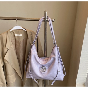 Détail du sac cabas lilas texturé avec logo M en métal argenté et boucles latérales