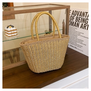 Detail showing metallic gold woven tote bag with sturdy double handles and beige lining