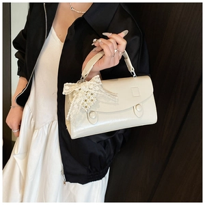 Dettaglio mini borsa squadrata bianco crema con fiocco in pizzo e catena di perle