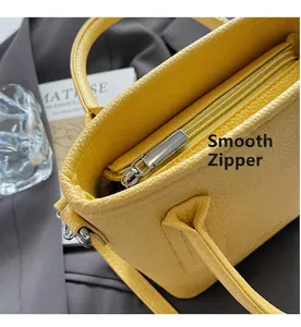 Detailed close-up of yellow litchi pattern leather bucket bag with smooth silver zipper
