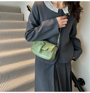 Retro avocado green underarm bag with double zipper and buckle detail on a model