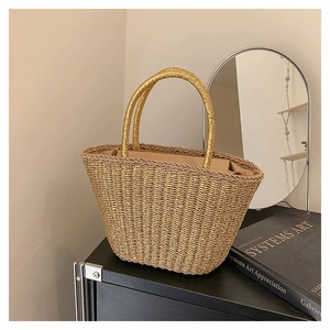 Detailed close-up of a woven golden tote bag with shiny metallic texture and round handles