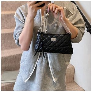 Détail du sac à main matelassé noir avec bandoulière chaîne argentée et fermoir rotatif