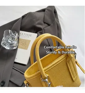 Detail of yellow lychee texture handbag with round handles and silver metal hardware