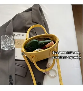 Internal view of yellow pebble leather bucket bag showing capacity for phones and makeup