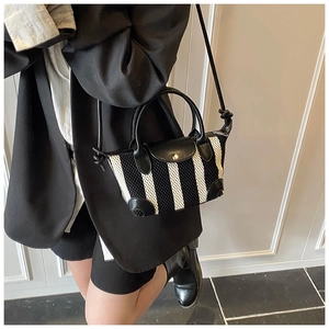 Modella con mini borsa a tracolla in mesh a strisce bianche e nere e patta in pelle