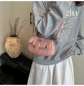 Pink matte leather crossbody bag with metal ring buckle shown in a lifestyle setting
