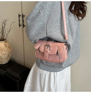 Detail of pink vintage shoulder bag with silver buckle and decorative side zippers