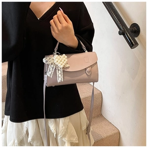 Dettaglio borsa lilla in pelle PU con ciondolo a cuore di perle e fiocco in pizzo