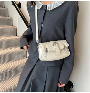 Detail of cream retro crossbody bag with silver metal ring buckle and smooth leather finish