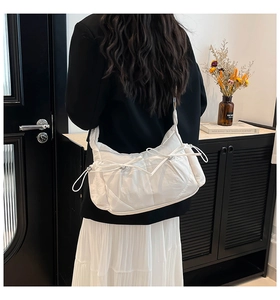 Détail du sac en nylon plissé blanc orné de deux nœuds et d'une bandoulière