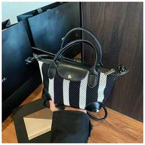 Dettaglio mini borsa a righe bianche e nere in tessuto mesh con eleganti rifiniture in pelle