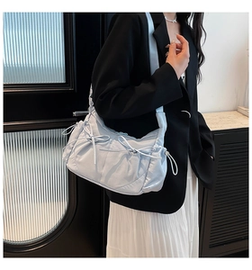 Détail du sac hobo en nylon bleu clair avec design plissé et nœuds à cordon