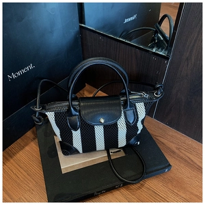 Dettaglio della mini borsa a righe con texture mesh e patta in pelle nera pregiata