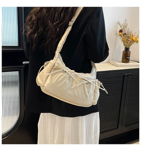 Détail du sac bandoulière en nylon blanc cassé avec plis et nœuds décoratifs