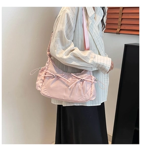 Détail du sac à bandoulière en nylon rose avec cordon de serrage et nœud doux