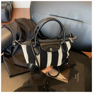 Dettaglio della texture a rete a righe con manico e patta in pelle sulla borsa a trapezio
