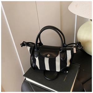 Dettaglio di una mini borsa a righe con patta in pelle e cerniera color argento