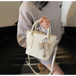 White lychee leather bucket bag with plaid bow and pearl heart charm detail