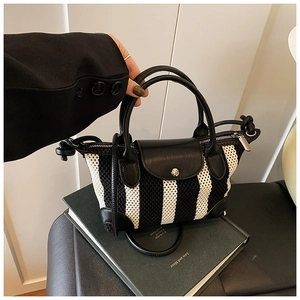 Dettaglio mini borsa a righe bianche e nere con manico e patta in pelle di qualità