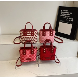 Detail showing red bridal mini tote bags with embroidery and gold hardware
