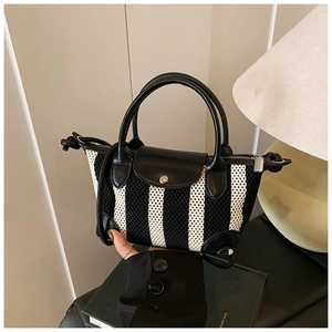 Dettaglio della maglia a righe e manici in pelle su una mini borsa a mano chic