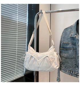 Détail d'un sac bandoulière en nylon blanc avec nœud papillon et large sangle réglable