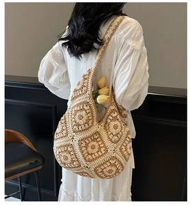 Handmade crochet tote bag with geometric floral patterns shown on a model's shoulder