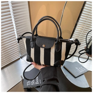 Dettaglio della trama a maglia a righe e patta in pelle di una borsa alla moda