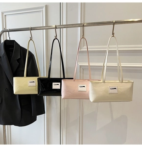 Detail view of glossy rectangular shoulder bags in yellow, black, pink, and white leather