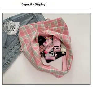 Détail montrant l'intérieur spacieux du sac cabas en toile à carreaux avec divers objets