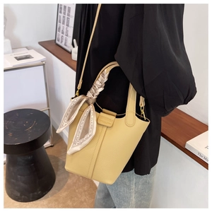 Litchi texture yellow bucket bag detail with decorative floral silk scarf handle