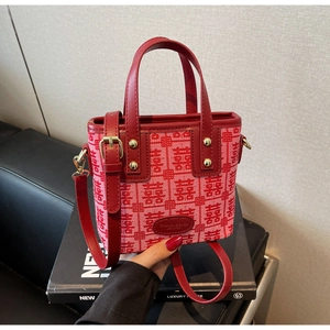 Detail of red wedding tote bag with traditional Chinese Xi jacquard pattern and leather handles