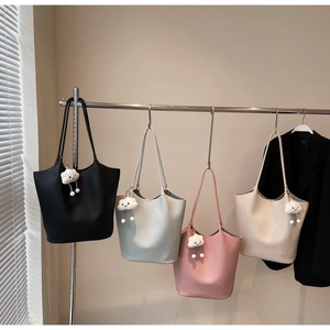 Row of minimalist leather bucket bags in four colors with cute white cloud charms