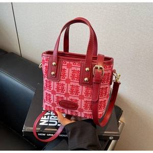 Detail of red bridal handbag with Xi characters, gold rivets and premium texture