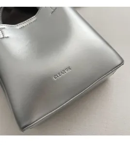 Close-up of pebble-textured silver bucket bag showing the CLEAROK logo engraving