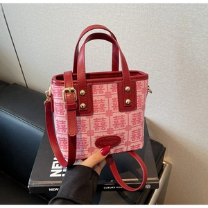 Detail of pink and red canvas wedding tote with Double Happiness pattern and leather trim
