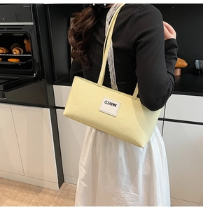 Pale yellow leather shoulder bag featuring a stylish Clear Heart K patch on the front