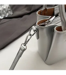 Detail shot of the polished silver hardware and metallic finish of the bucket bag