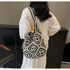 Detailed view of handmade crochet shoulder bag with black and white sunflower pattern
