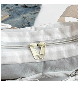 Détails du double fermoir à glissière sur un sac à bandoulière léger en tissu de nylon